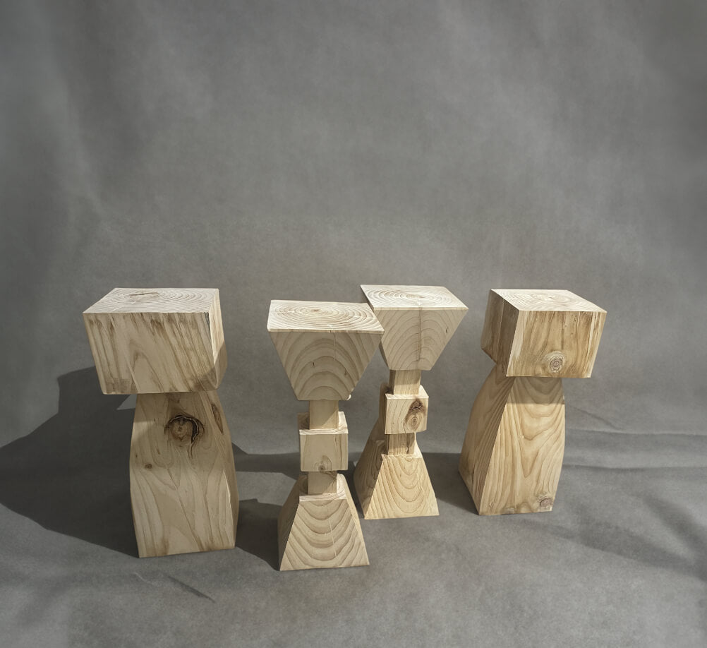 Set of 4 solid wood kitchen stools with a natural finish on a gray backdrop.